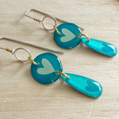 Aqua heart drop earrings on a wooden surface