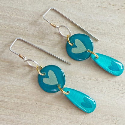 aqua heart-shaped earrings on a wooden surface