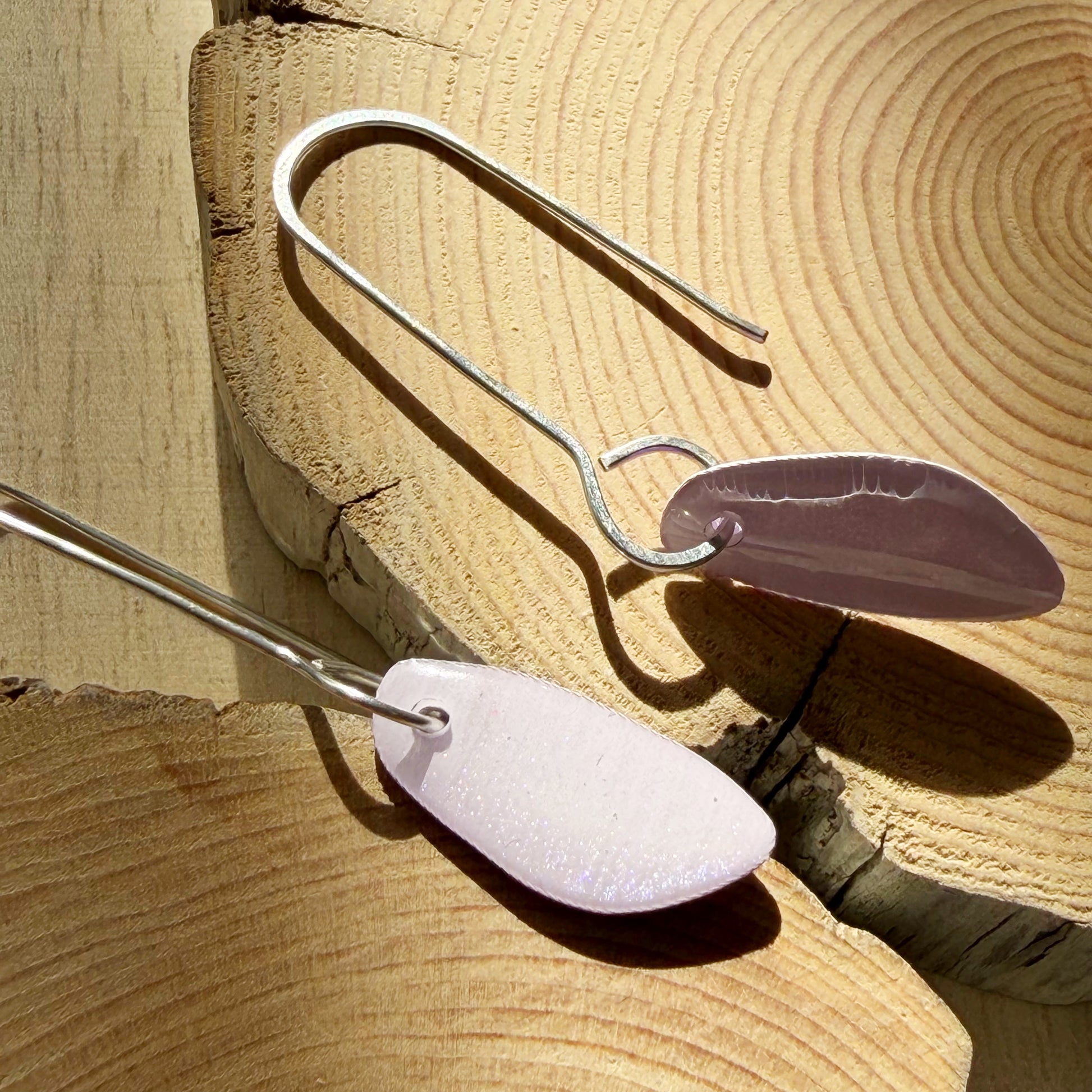 lavender coloured organic teardrop earrings on wooden surface